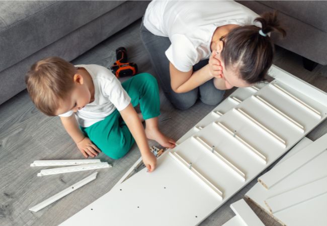Mom and little boy assembling IKEA furniture